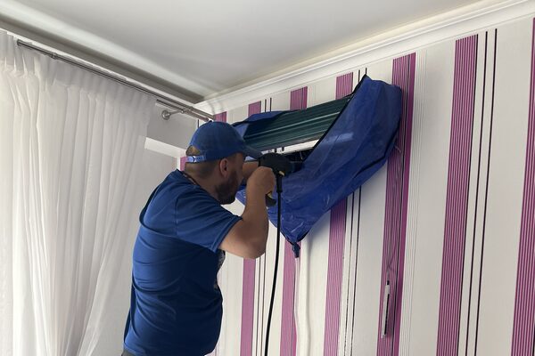 Técnico lavando la unidad interior con un equipo de presión