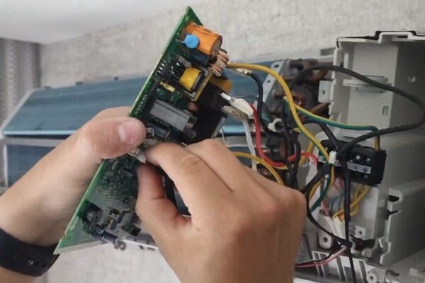 Técnico diagnosticando la placa electrónica de un aire acondicionado